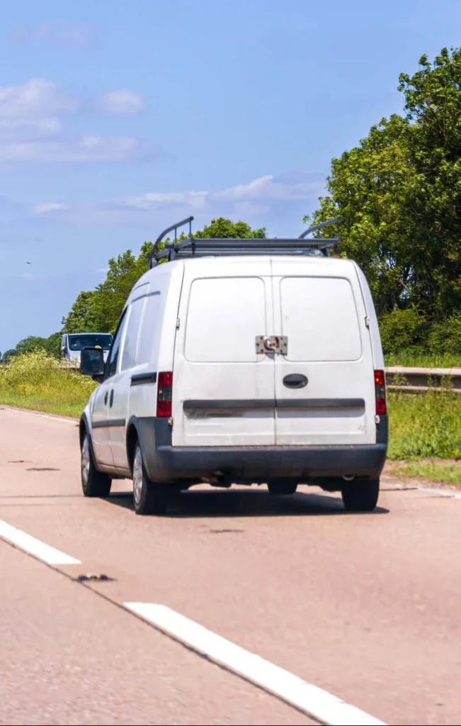 Work van driving on a quiet road