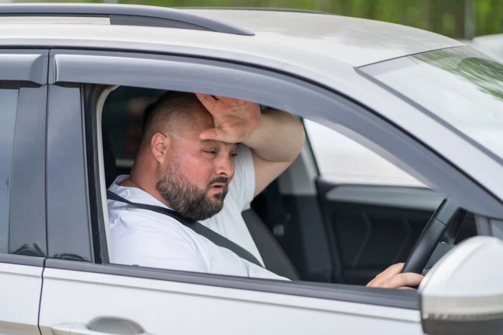 Drunk driver waving at the camera with his window rolled down