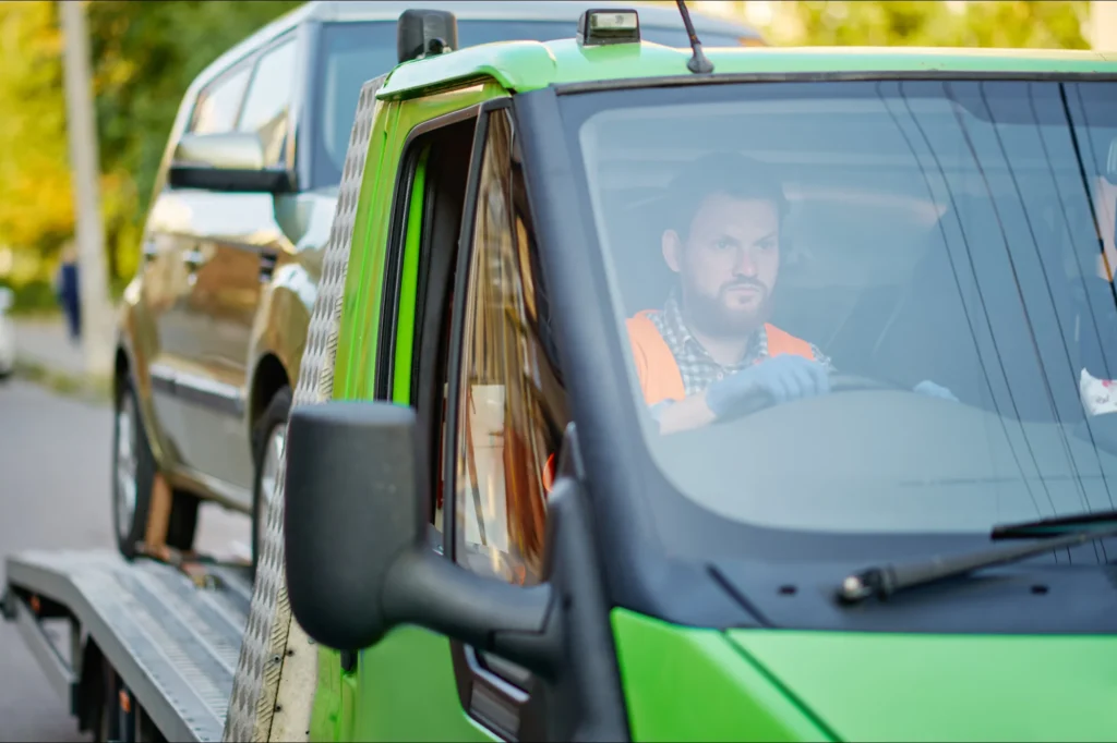 Vehicle collections or delivery driver with a car on the back of his truck