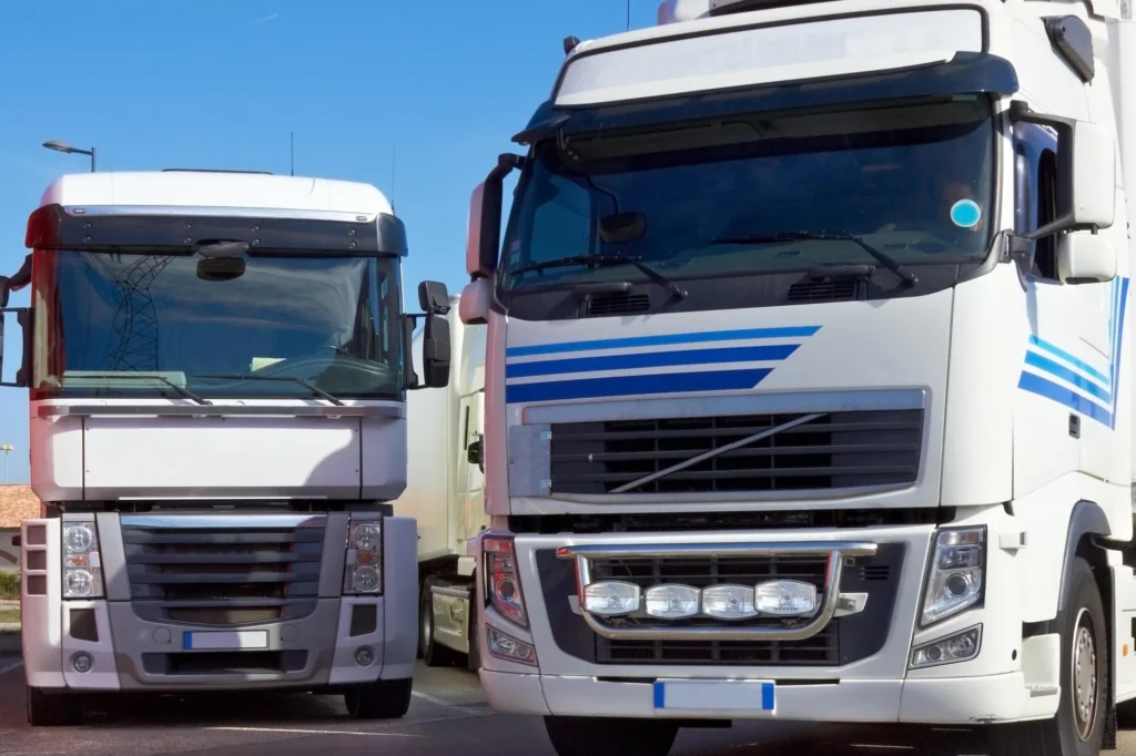 Small fleet of two large trucks parked next to eachother