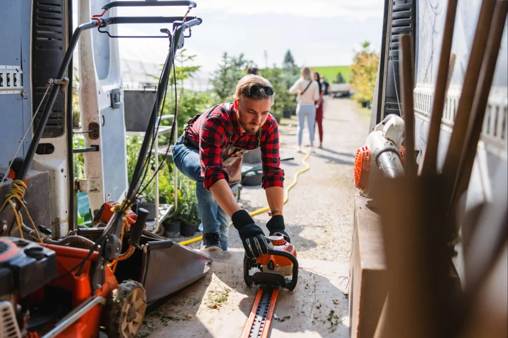 Gardener or landscaper retrieving items from the back of his work van