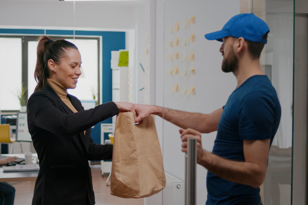 Man handing over the fadt food delivery to the customer