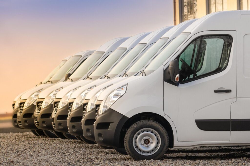 A fleet of courier vans all parked next to each other