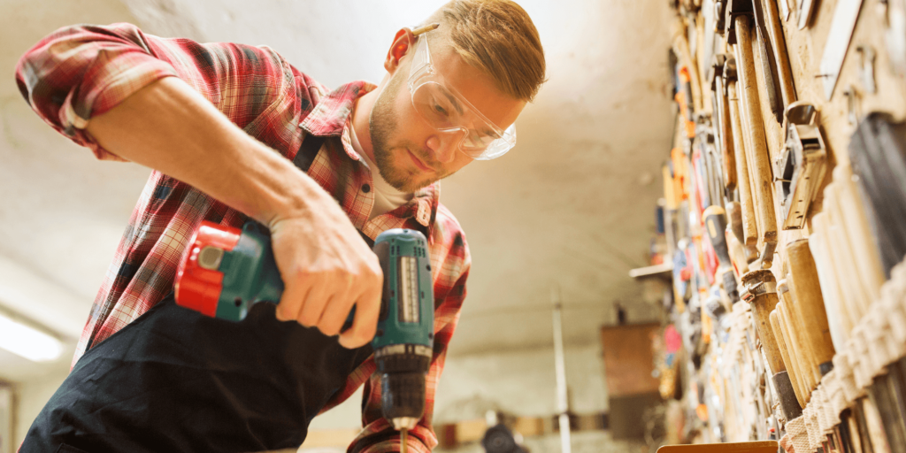 Handyman using a cordless drill to install shelving in a client’s home.